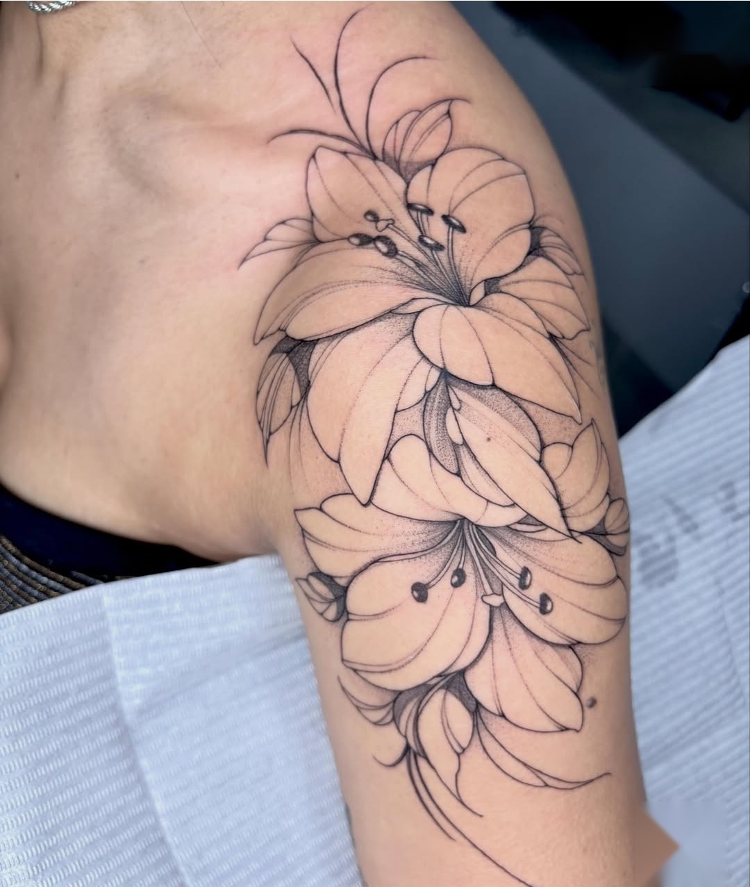 Tatuagem de lírios em fineline no braço